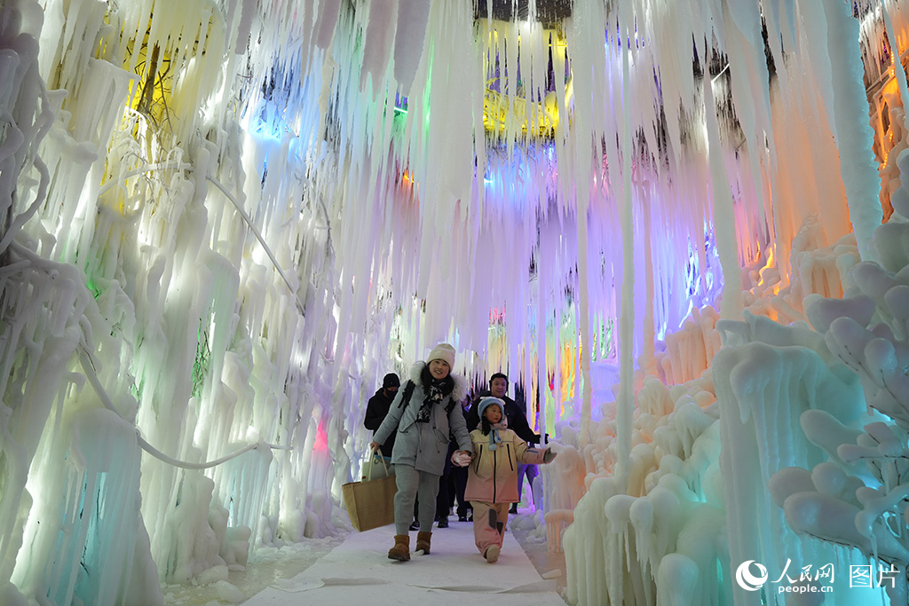 12月16日，游客在吉林長(zhǎng)春冰雪新天地景區(qū)的冰洞里欣賞冰雕藝術(shù)。人民網(wǎng)記者 李洋攝