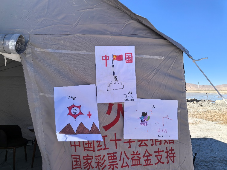 孩子們把自己的畫(huà)貼在了工作站帳篷上。中國(guó)紅十字會(huì)總會(huì)供圖